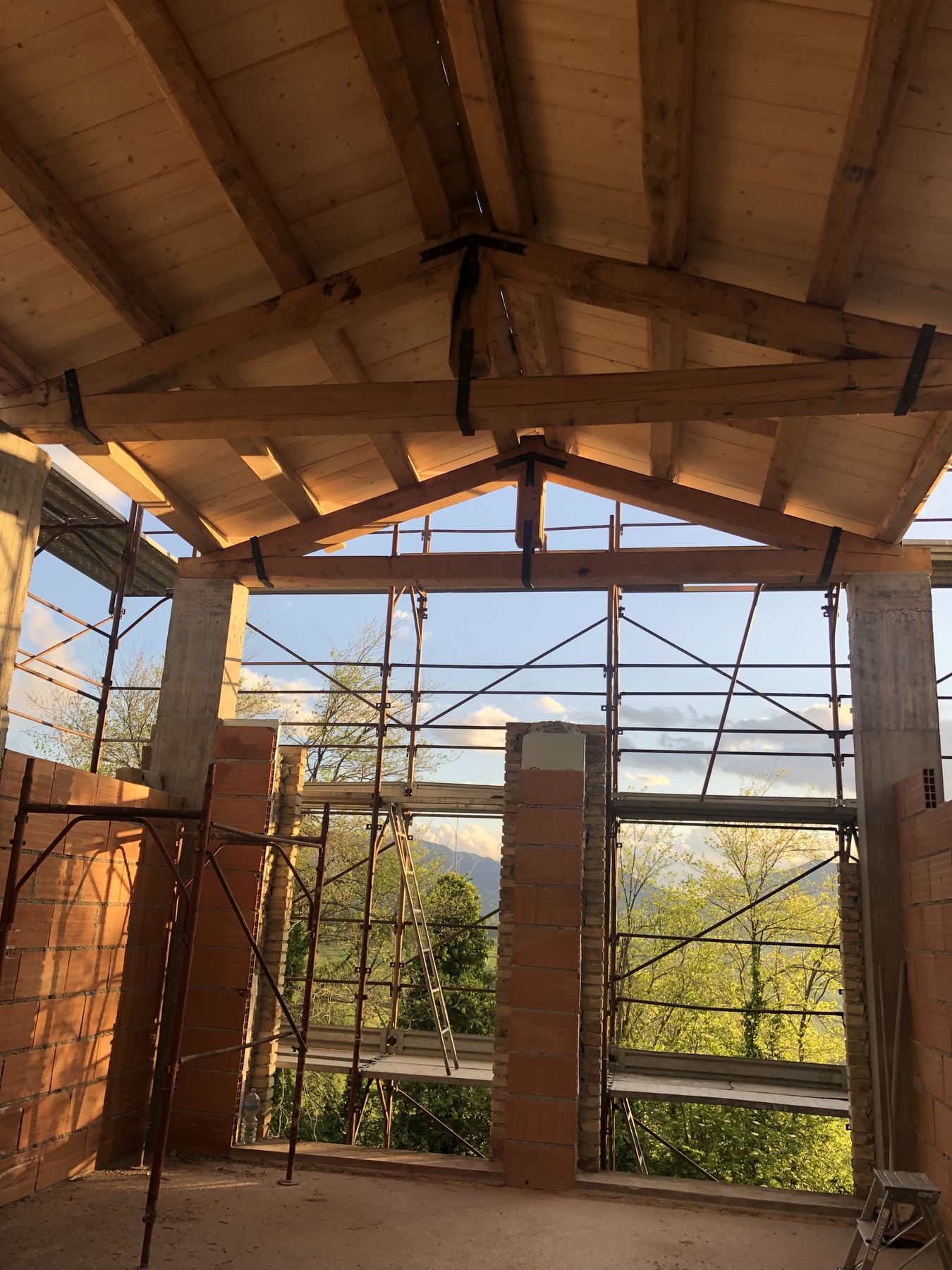 Nuova orditura del tetto in legno con capriata a vista, vista dall'interno con ponteggio ancora in opera